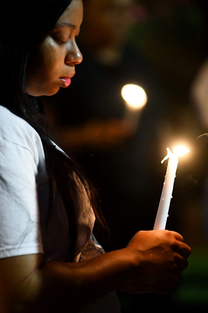Imani Perry looks at a candle lit in honor of Nadria Wright